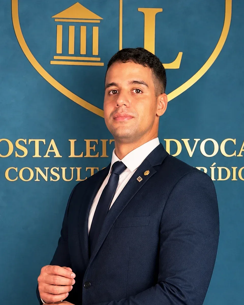 Dr. Bruno Costa Leite, de terno azul-marinho e gravata, diante da parede azul com o brasão dourado do escritório.